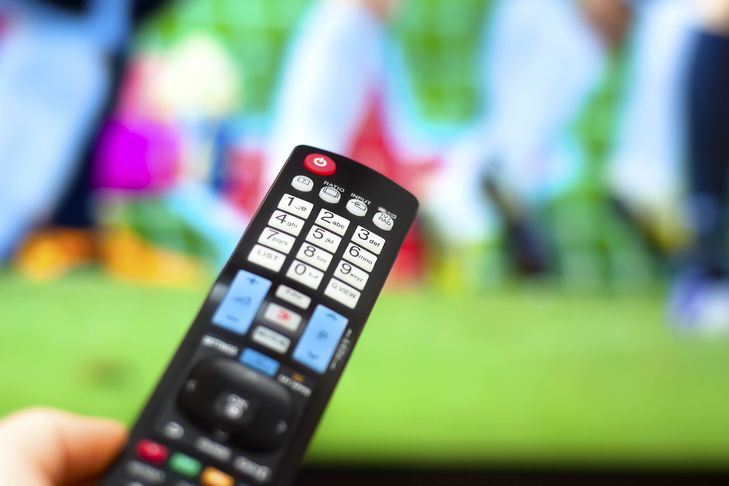 TV remote being used to watch sport