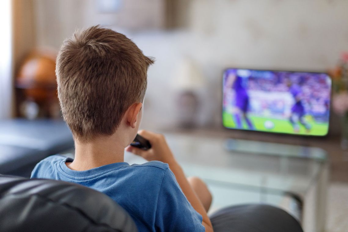 A child watching sport in his bedroom